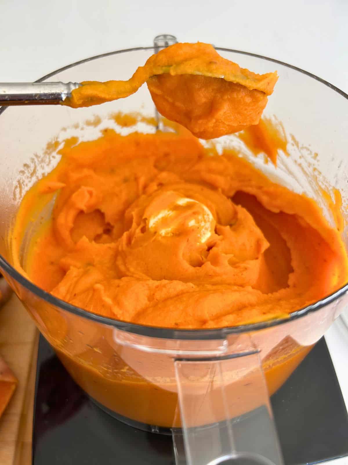 An upside-down spoonful of chipotle sweet potato puree showing how thick it is.