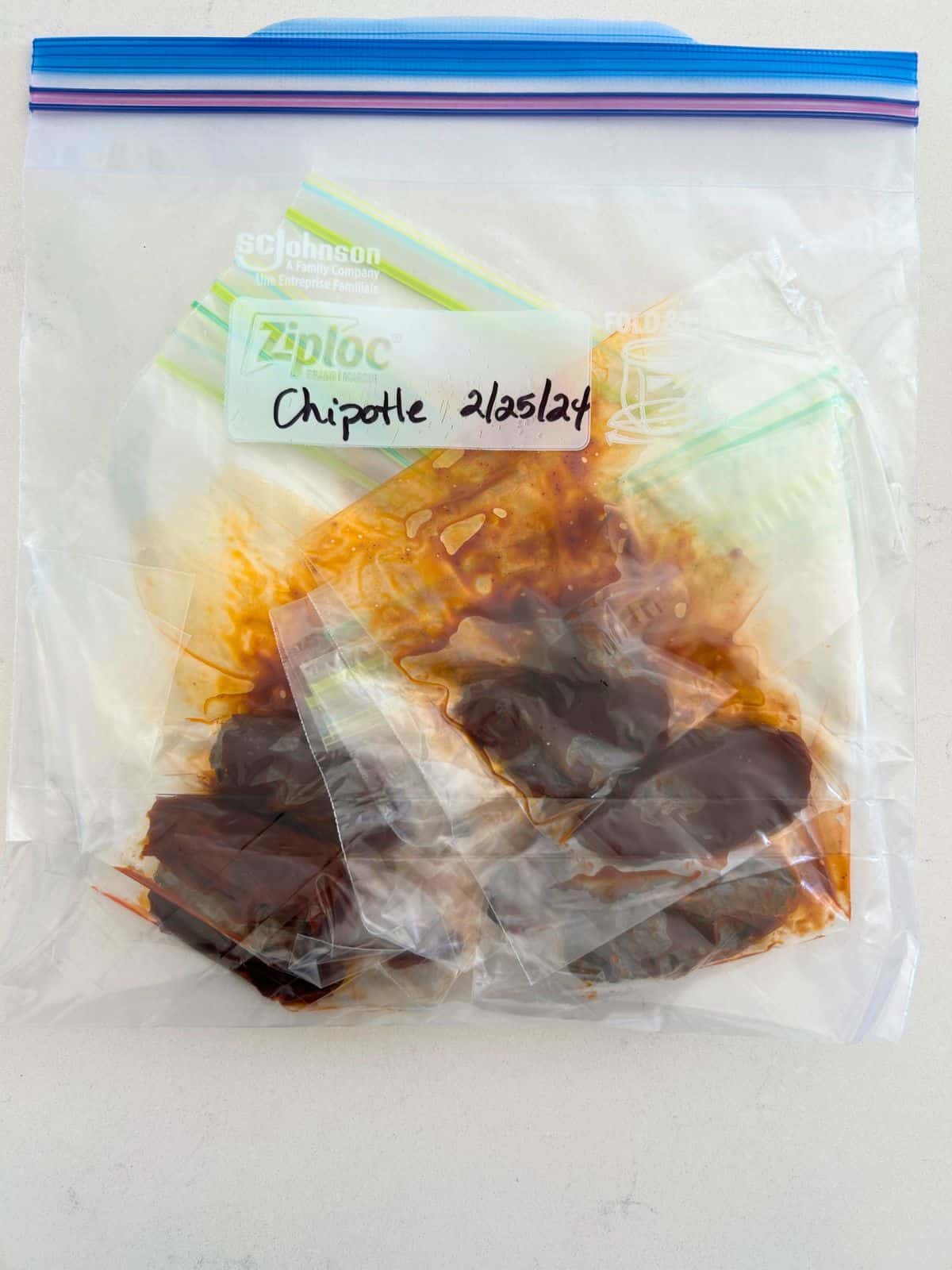 One gallon freezer ziplock bag filled with individual chipotle peppers to freeze for next time.