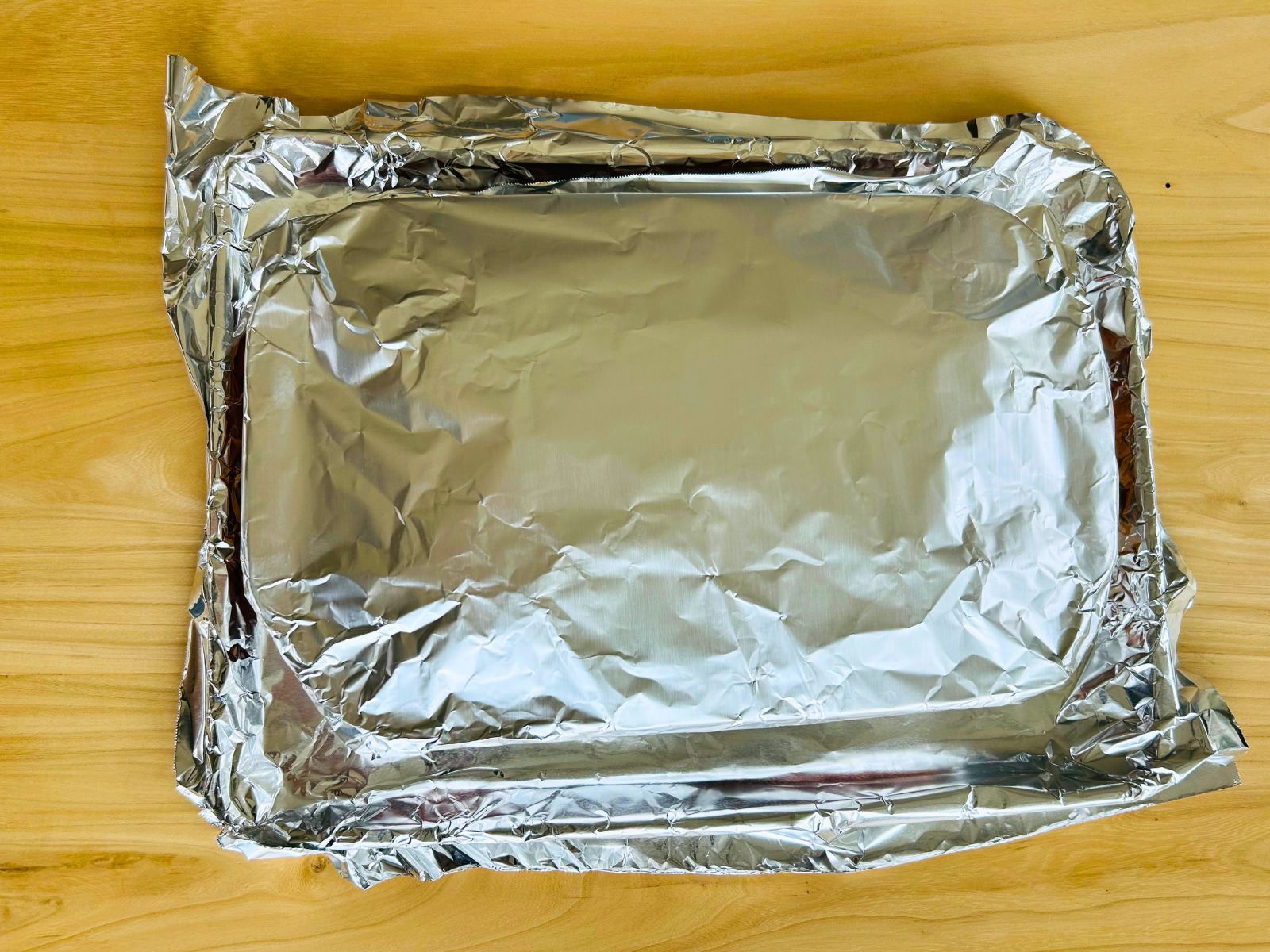 The casserole dish of lasagna is prepped and covered in foil awaiting the oven.