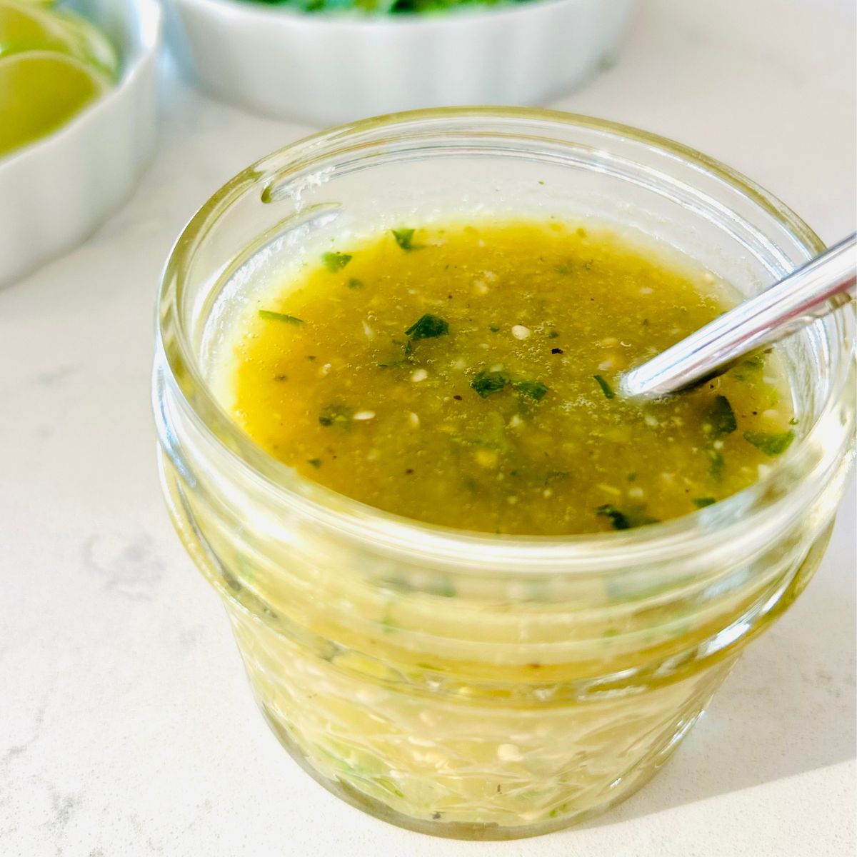 Tomatillo green chili salsa in a small mason jar with a spoon.