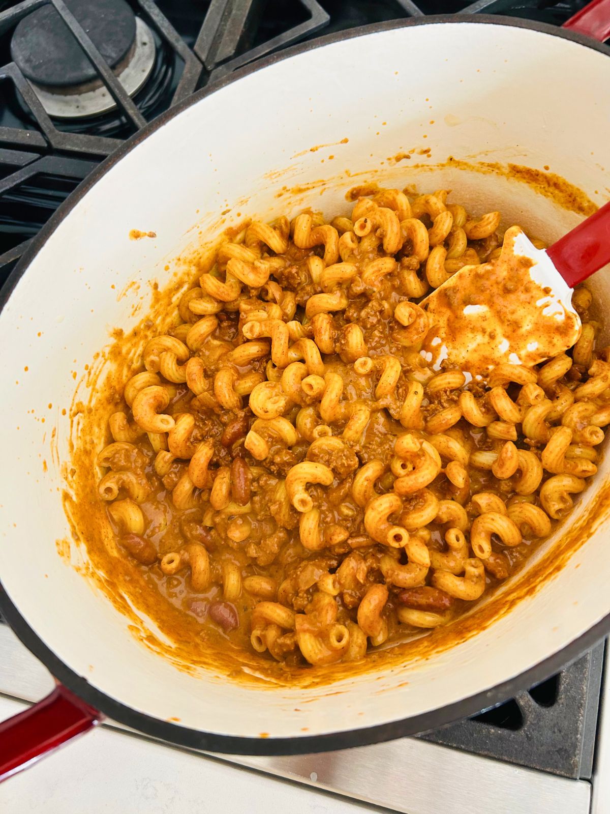 A pot of chili mac with the leftover chili mixed into the cheesy pasta.