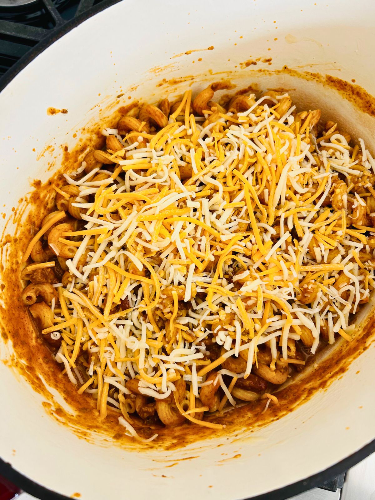 Chili mac with leftover chili with unmelted shredded colby jack cheese sprinkled on top.