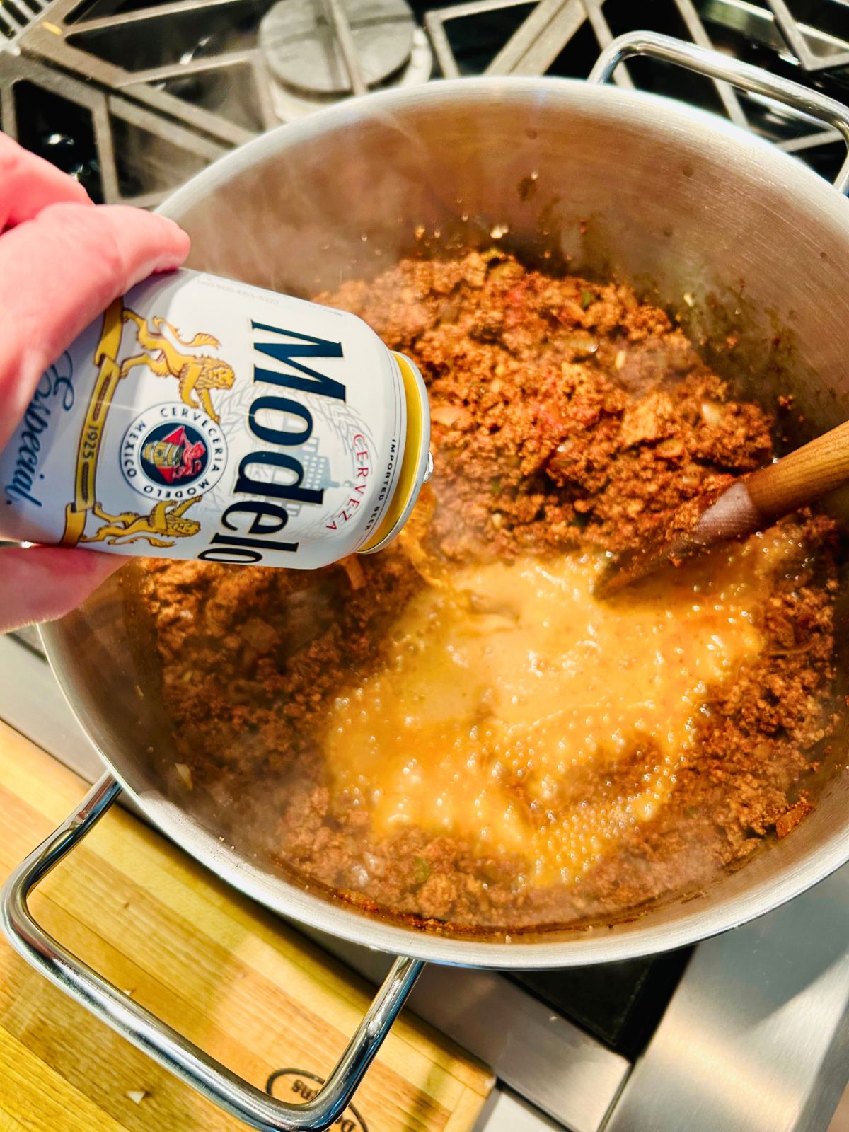 A can of Modelo pilsner beer pouring into the pot.