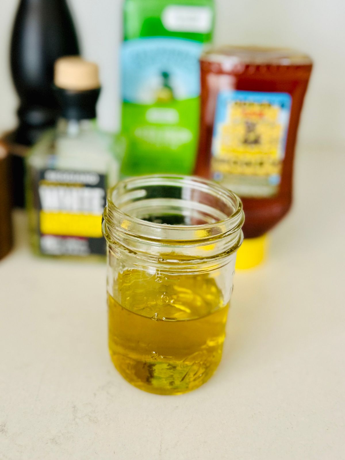 A mason jar with 4 ounces of olive oil in it.