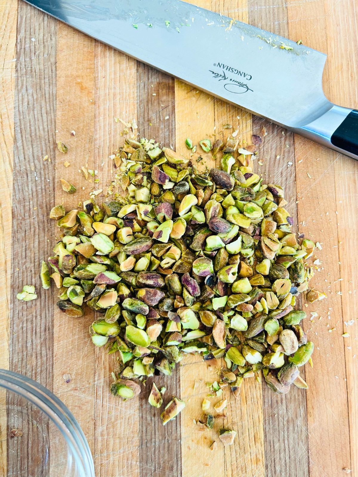 Chopped pistachio nuts on a cutting board.