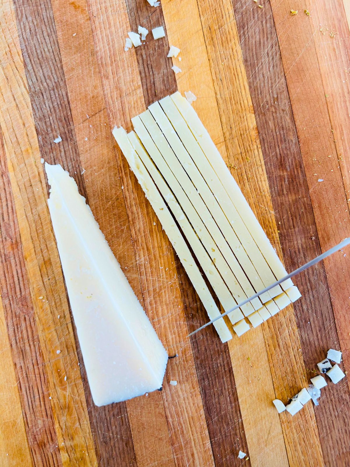 Pecorino Romano cheese wedge that has been thinly sliced and then cubed into small squares.