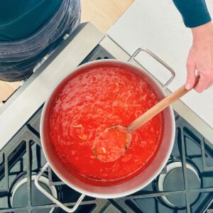 San Marzano marinara sauce and a wooden spoon simmering on the stove.