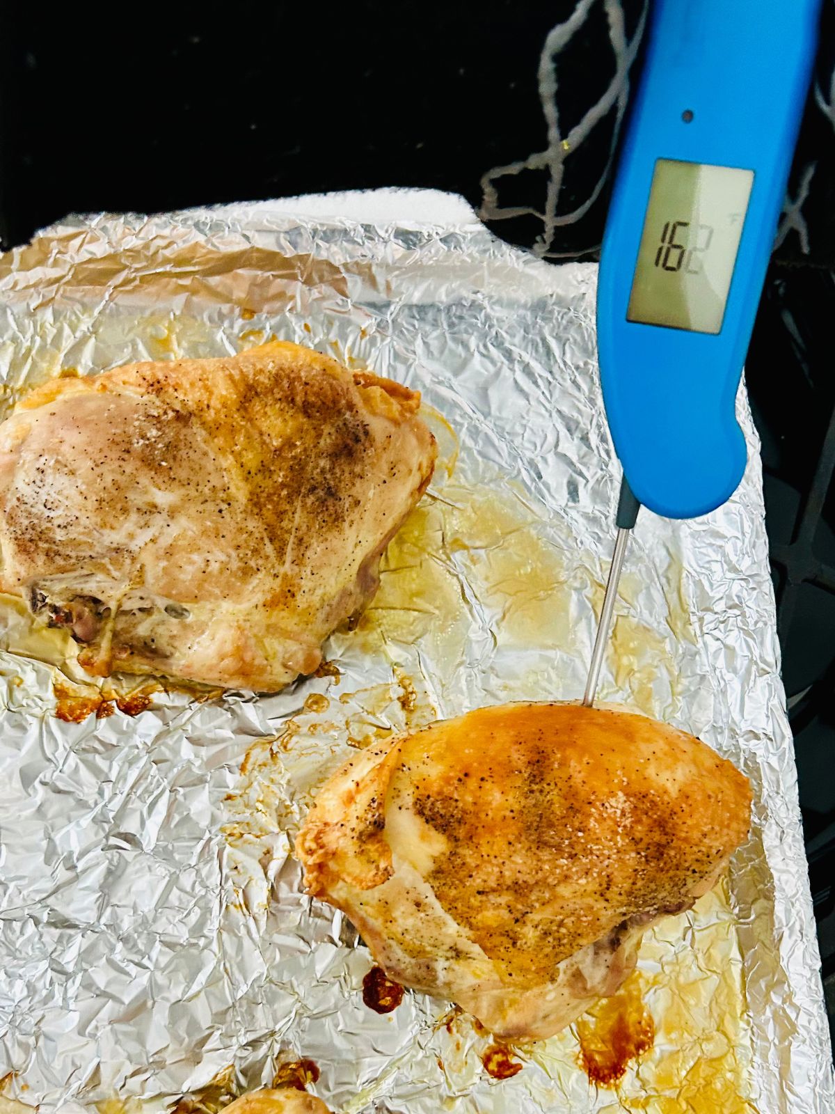 Checking the internal temperature of a roasted split chicken breast.