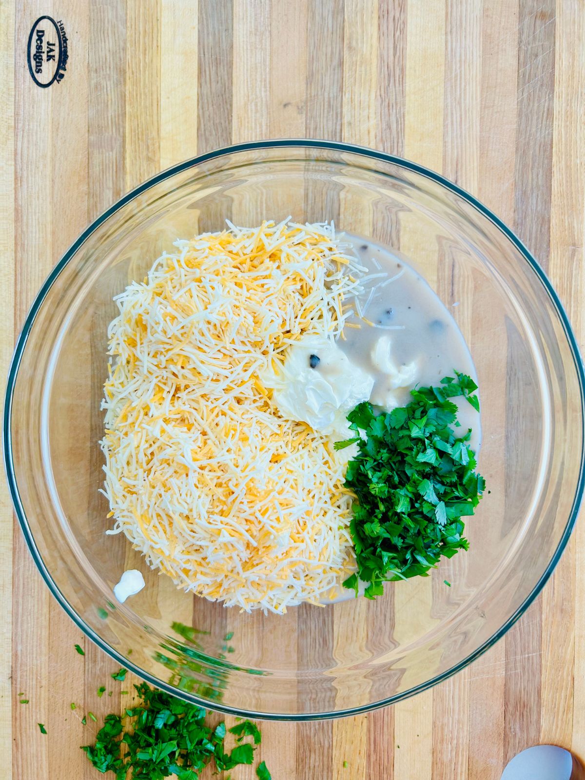 The sour cream, mushroom soup, shredded cheese, and chopped cilantro in a mixing bowl.