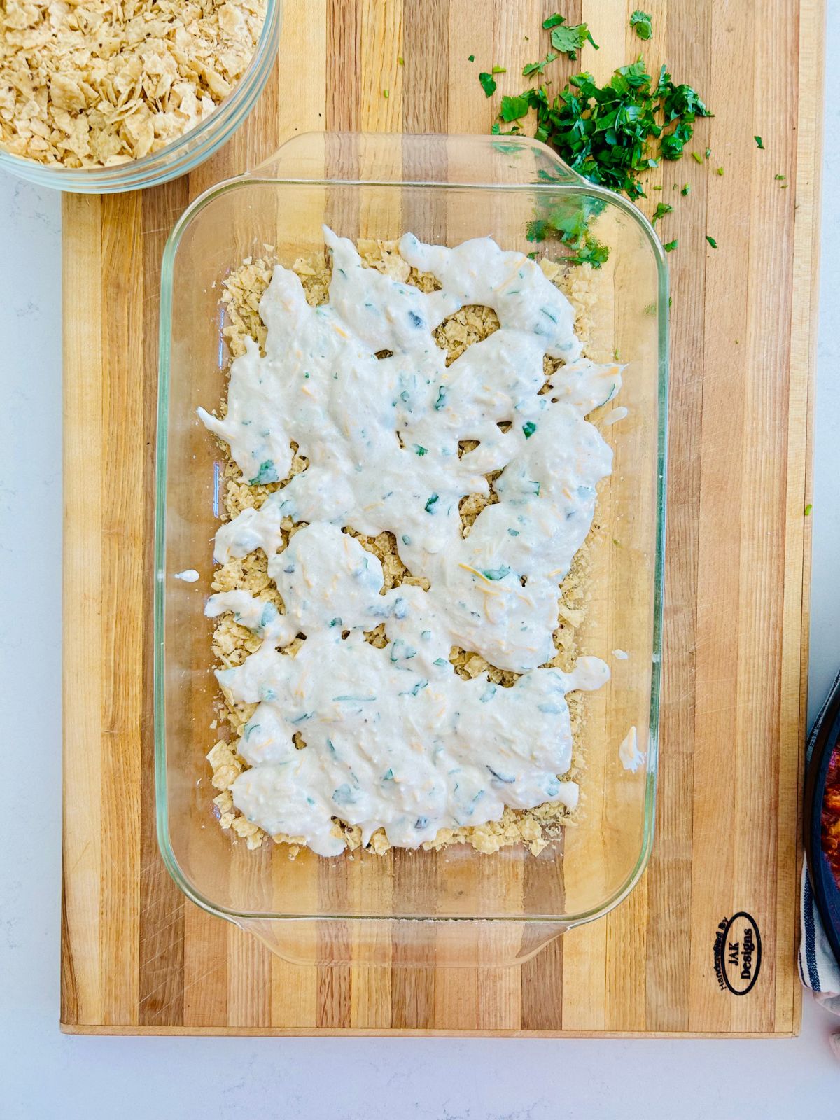 The second layer is a sour cream mixture and spooned on top of the crushed tortilla chips.