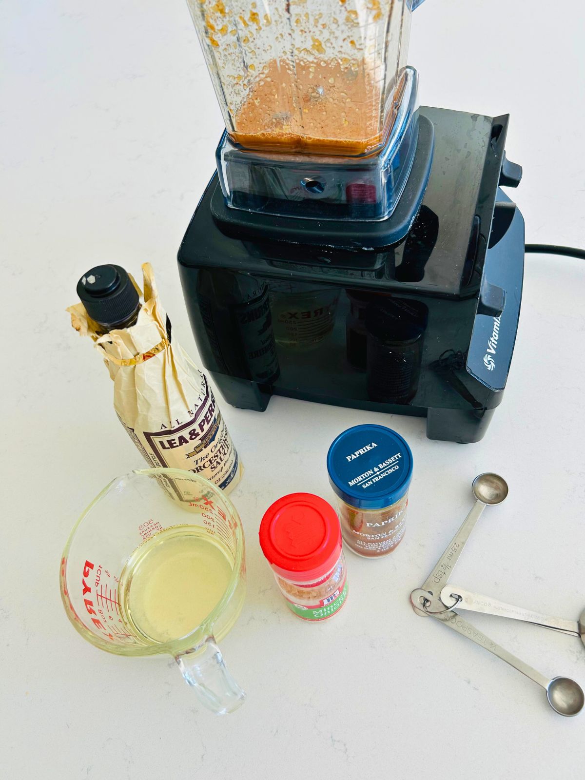 Apple cider vinaigrette ingredients combined in a blender before adding canola oil to the pitcher.