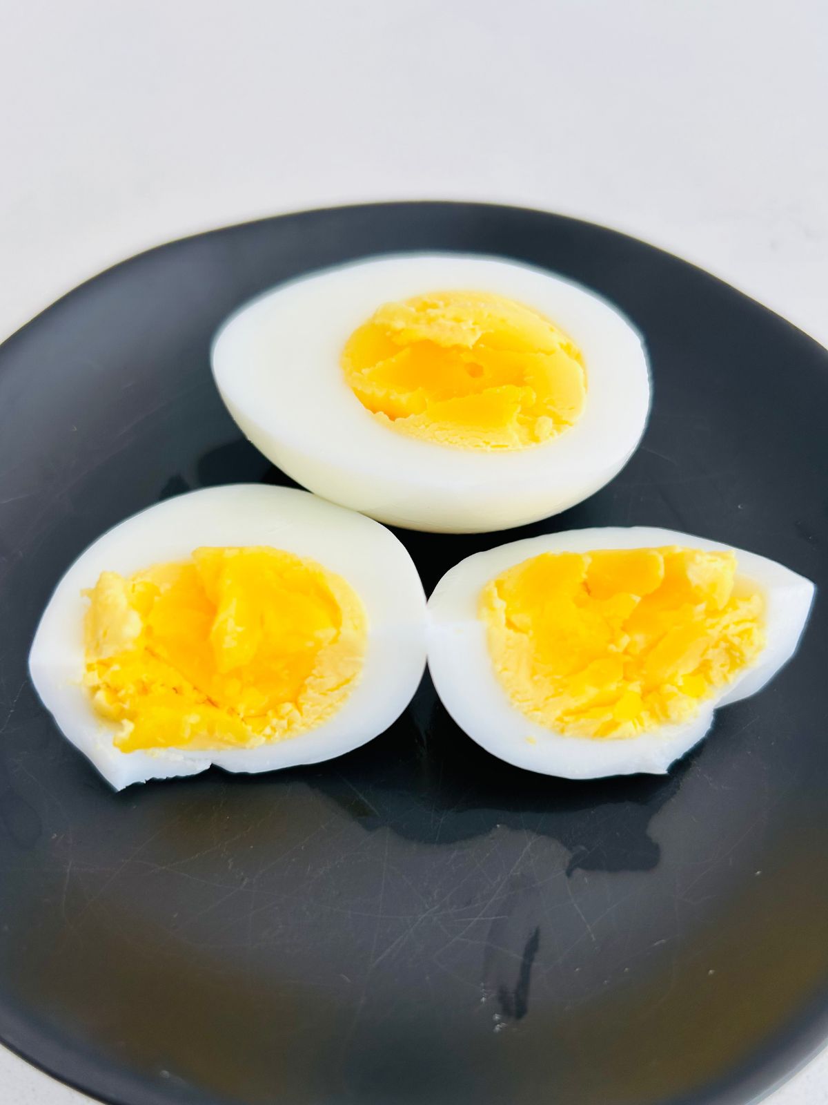 A close up view of a quick and easy hard boiled egg split open.