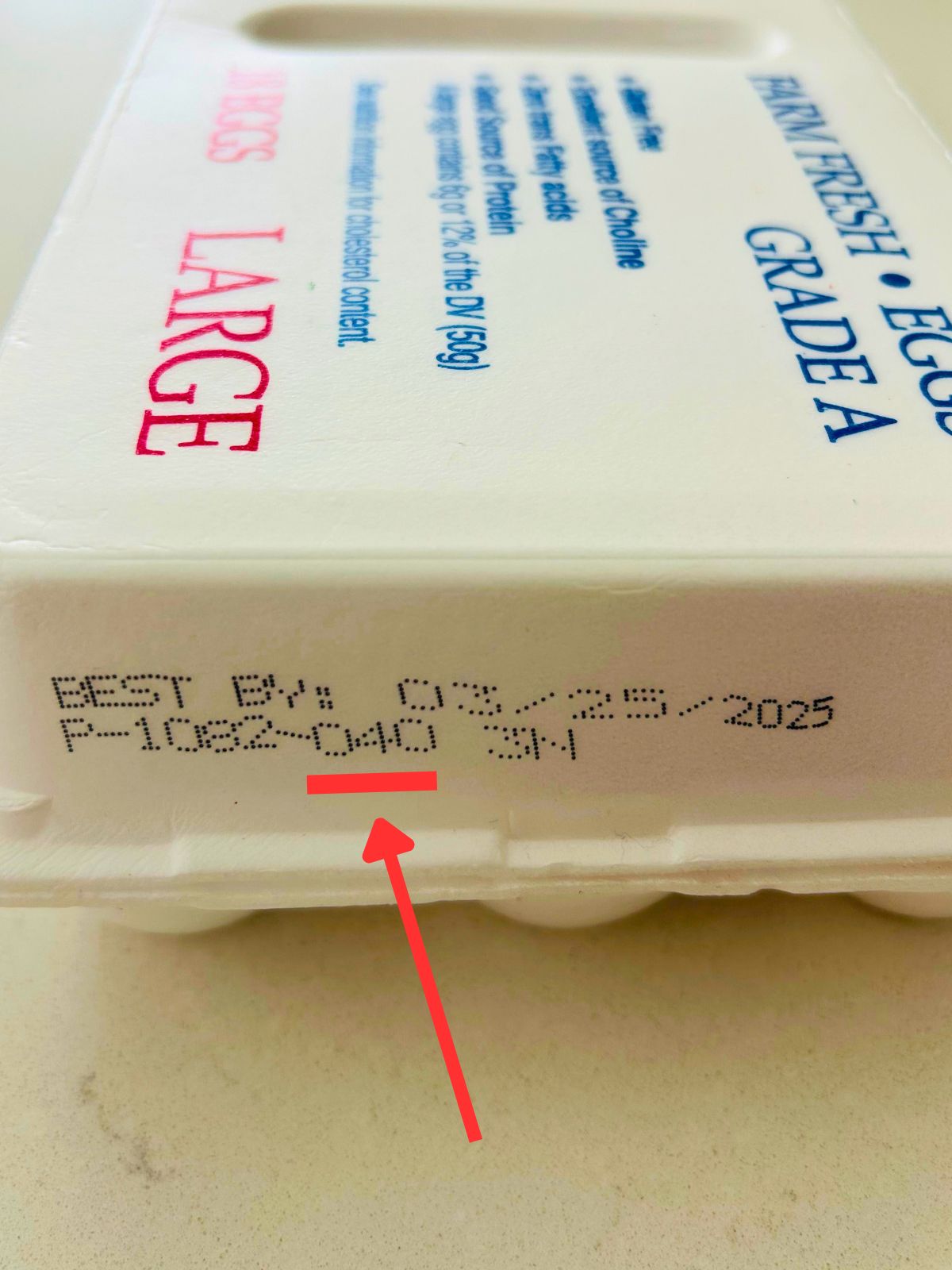 The ink stamp on the side of package of fresh eggs showing the 3 digit number package date.