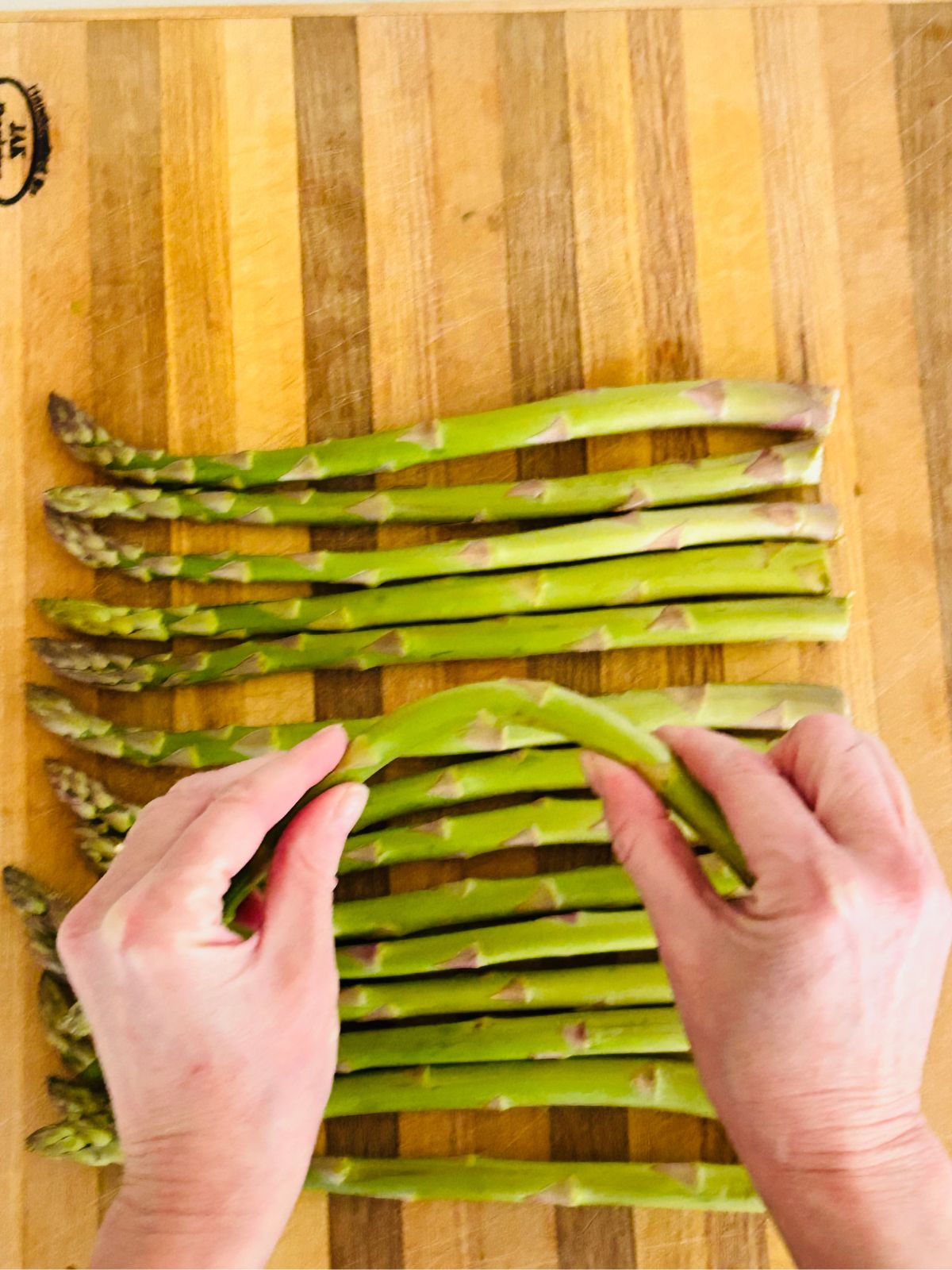 Bend an asparagus spear so it snaps off the end.