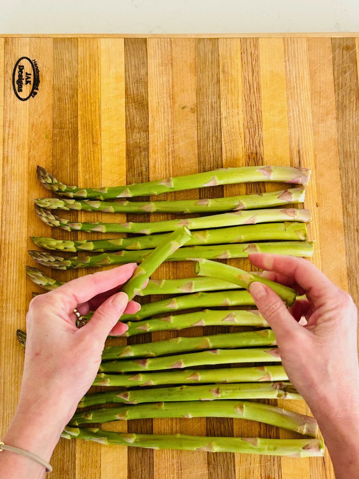 Snap one end of an asparagus spear to judge where to cut the rest of the woody ends.