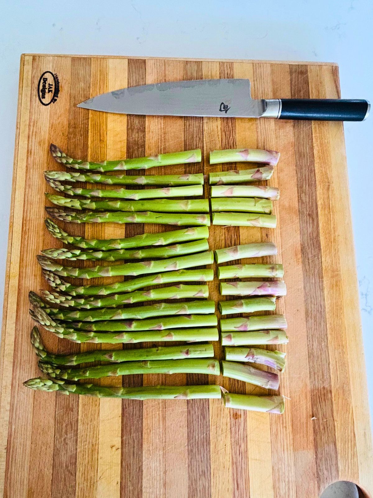 Preparing the asparagus spears by cutting off the woodsy ends.