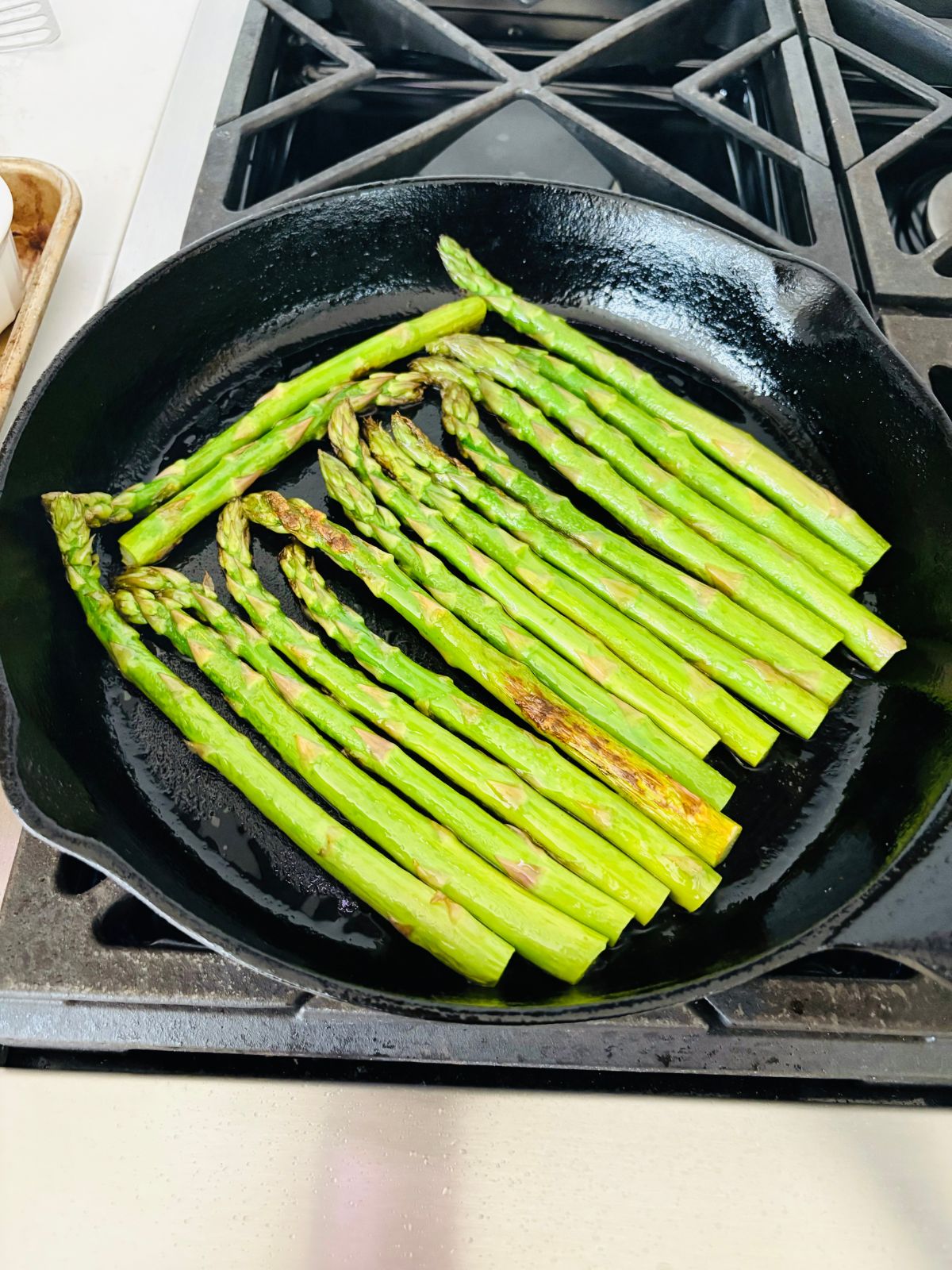 The asparagus sears are starting to sear in the hot skillet.