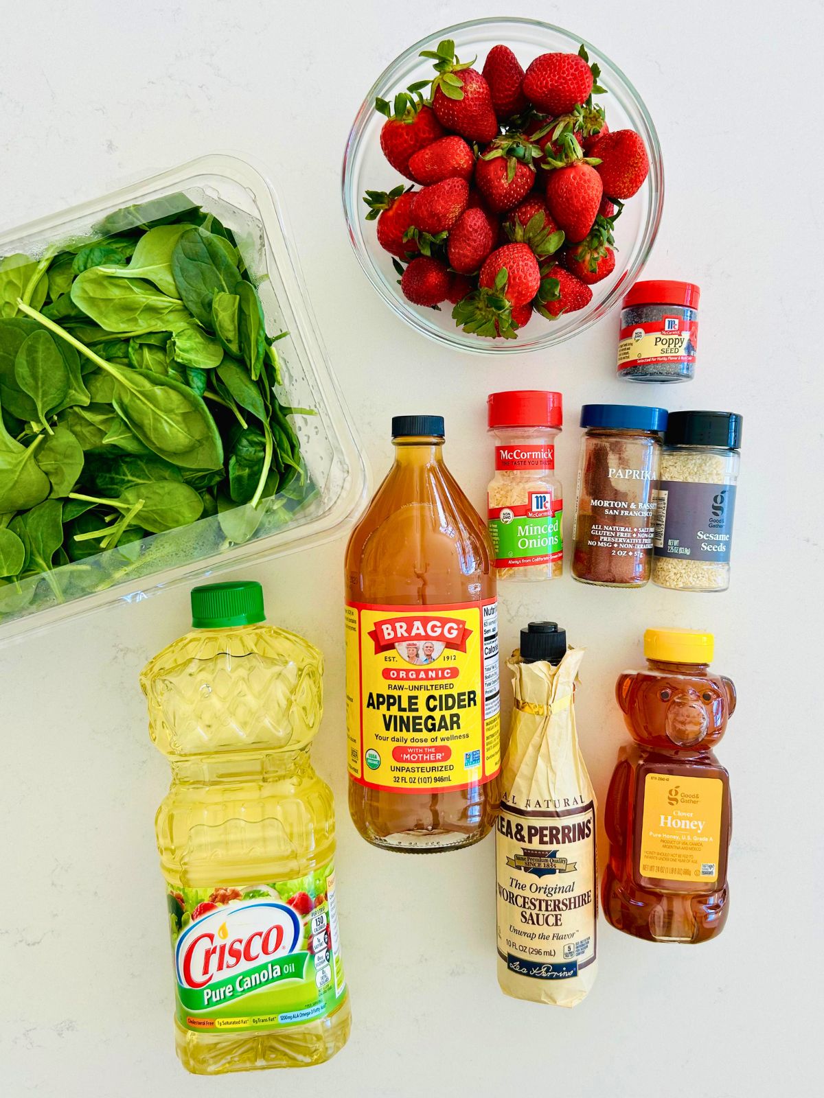 The ingredients to make strawberry spinach salad with apple cider vinaigrette.