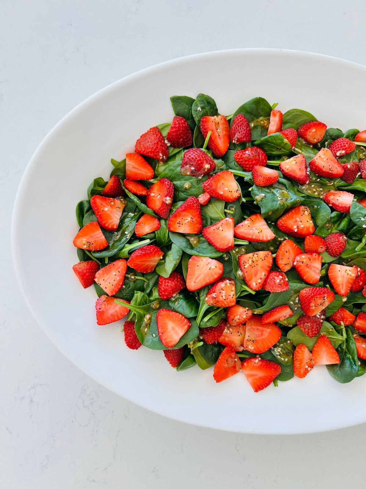 Spinach and strawberry salad fully assembled and ready to serve.