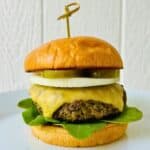 A juicy, grilled turkey burger with mushrooms in a brioche bun with cheese, lettuce, onion, and pickles.