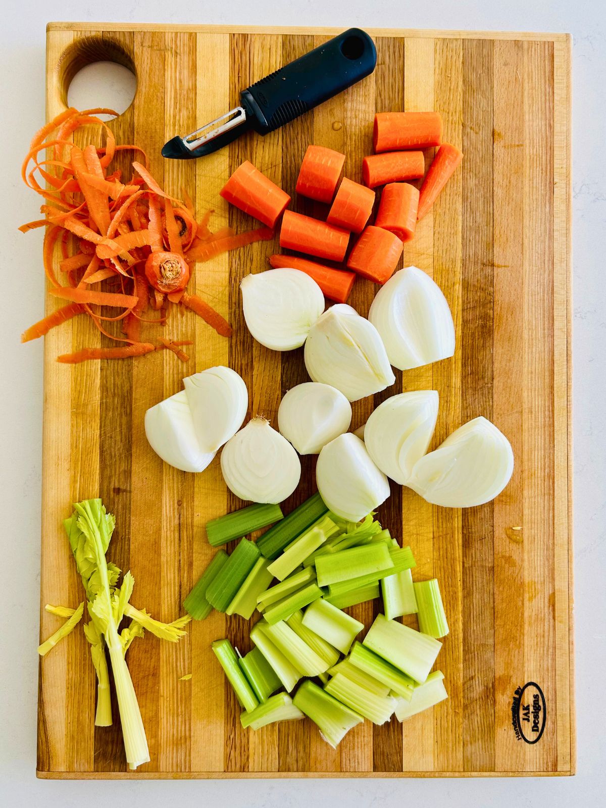 The mirepoix of onions, celery, and carrots are clean, peeled, and roughly chopped.