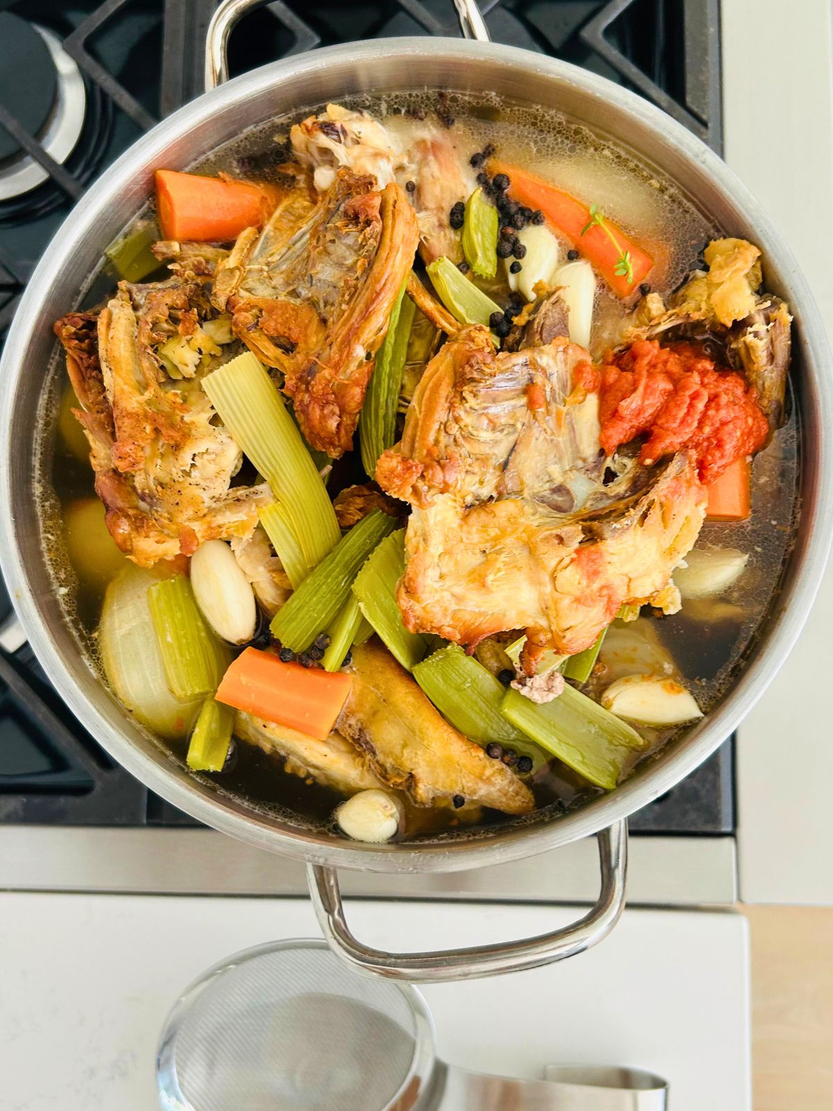 Water is added to a pot containing all of the ingredients needed to make brown stock.