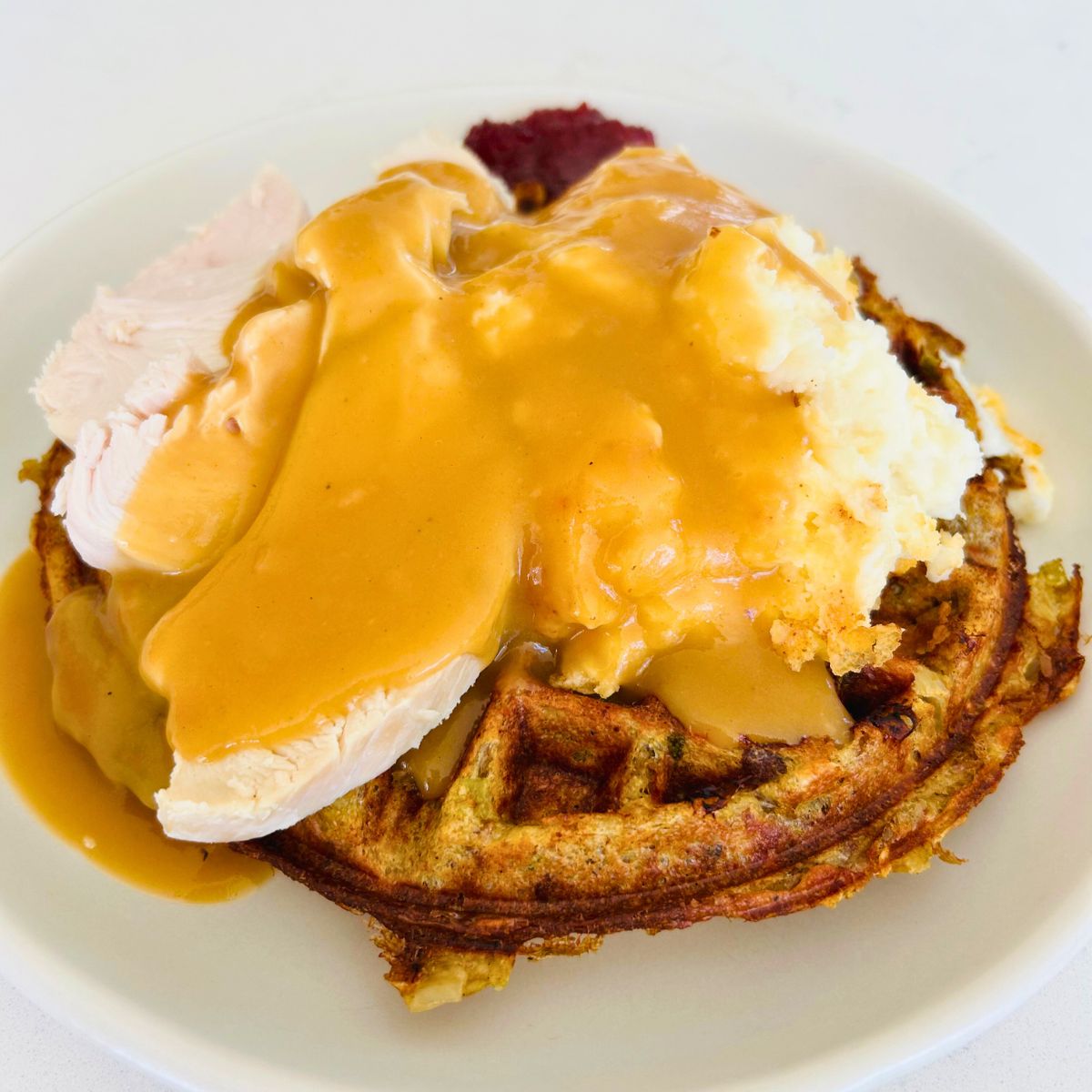 Gravy made with brown chicken stock and spooned over turkey, mashed potatoes, and a stuffing waffle.