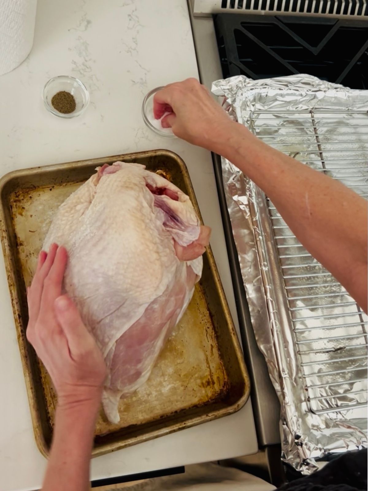 Seasoning the turkey breast with salt and pepper.