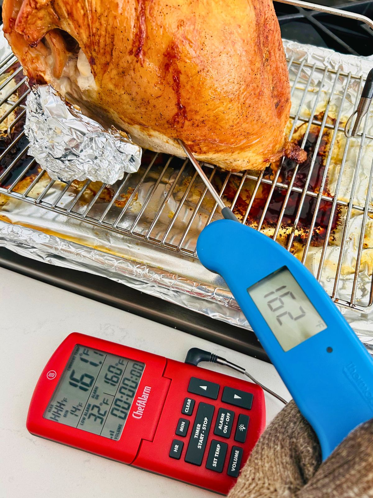 Checking the internal temperature of the other side of the turkey breast with a thermometer to make sure it is done.