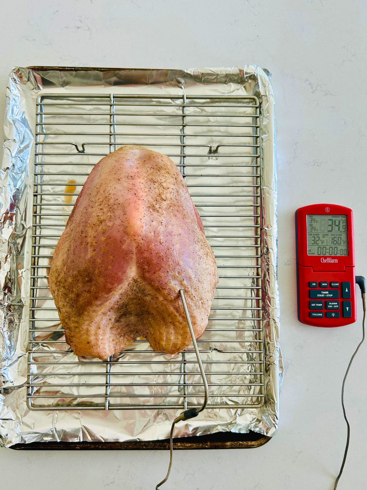 A probe thermometer has been inserted into the thickest part of the turkey breast before roasting.