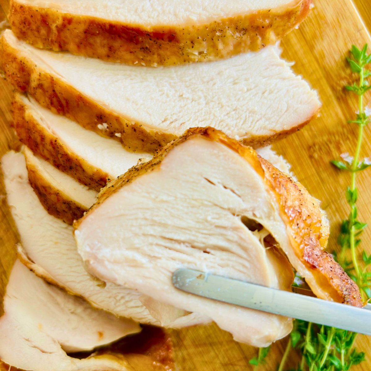 Sliced oven roasted turkey breast on a cutting board.