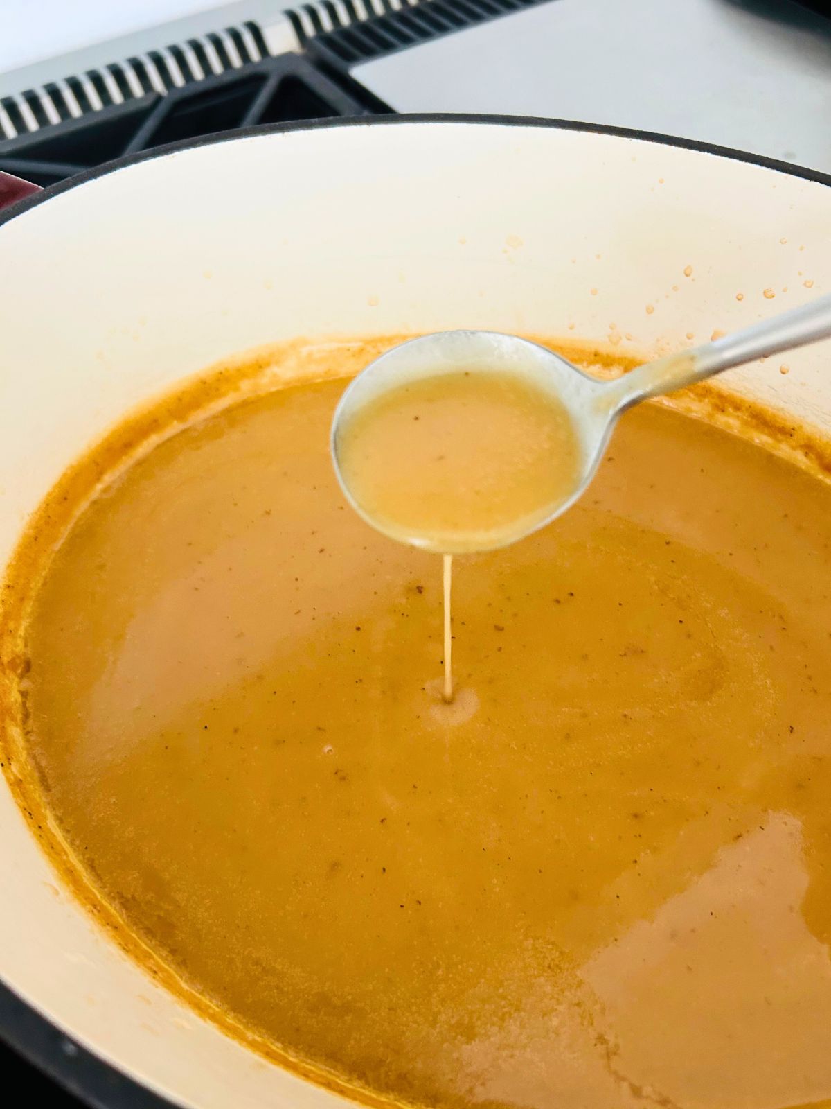 Simmering and stirring the turkey gravy until it's reduced and ready to serve.