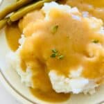 A plate with turkey gravy recipe without drippings over mashed potatoes.