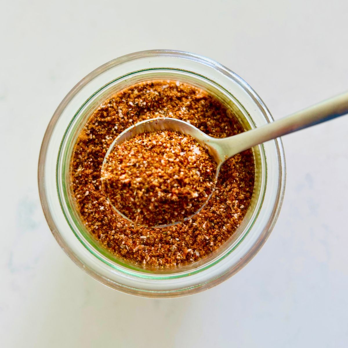 Espresso rub in a spoon held over a mason jar.