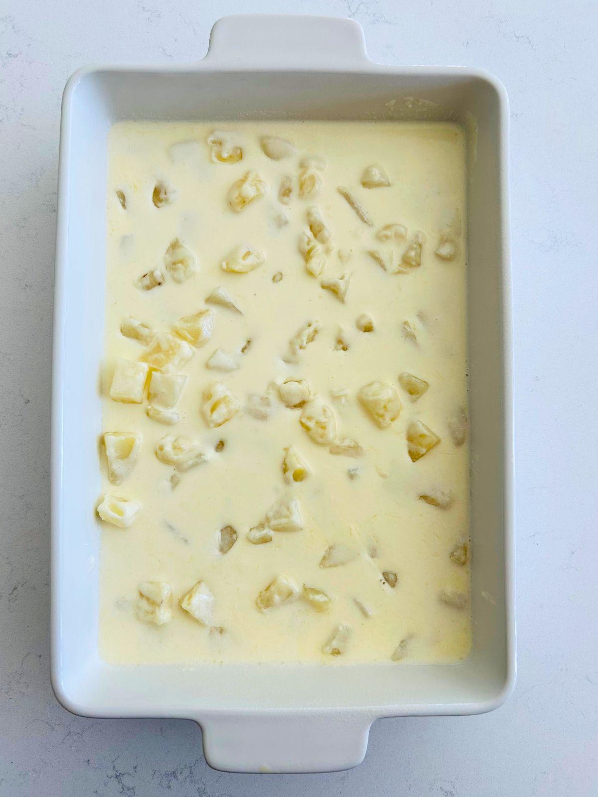 A casserole of cubed and parboiled chunks of potatoes in cream.
