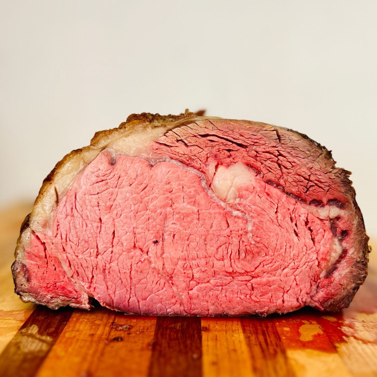 The cut side of a slow roasted prime rib recipe resting on a cutting board.