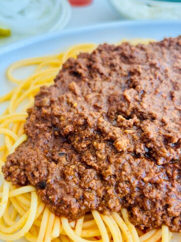 Fred and Red's copycat spaghetti red recipe with chili spooned on top of spaghetti noodles.