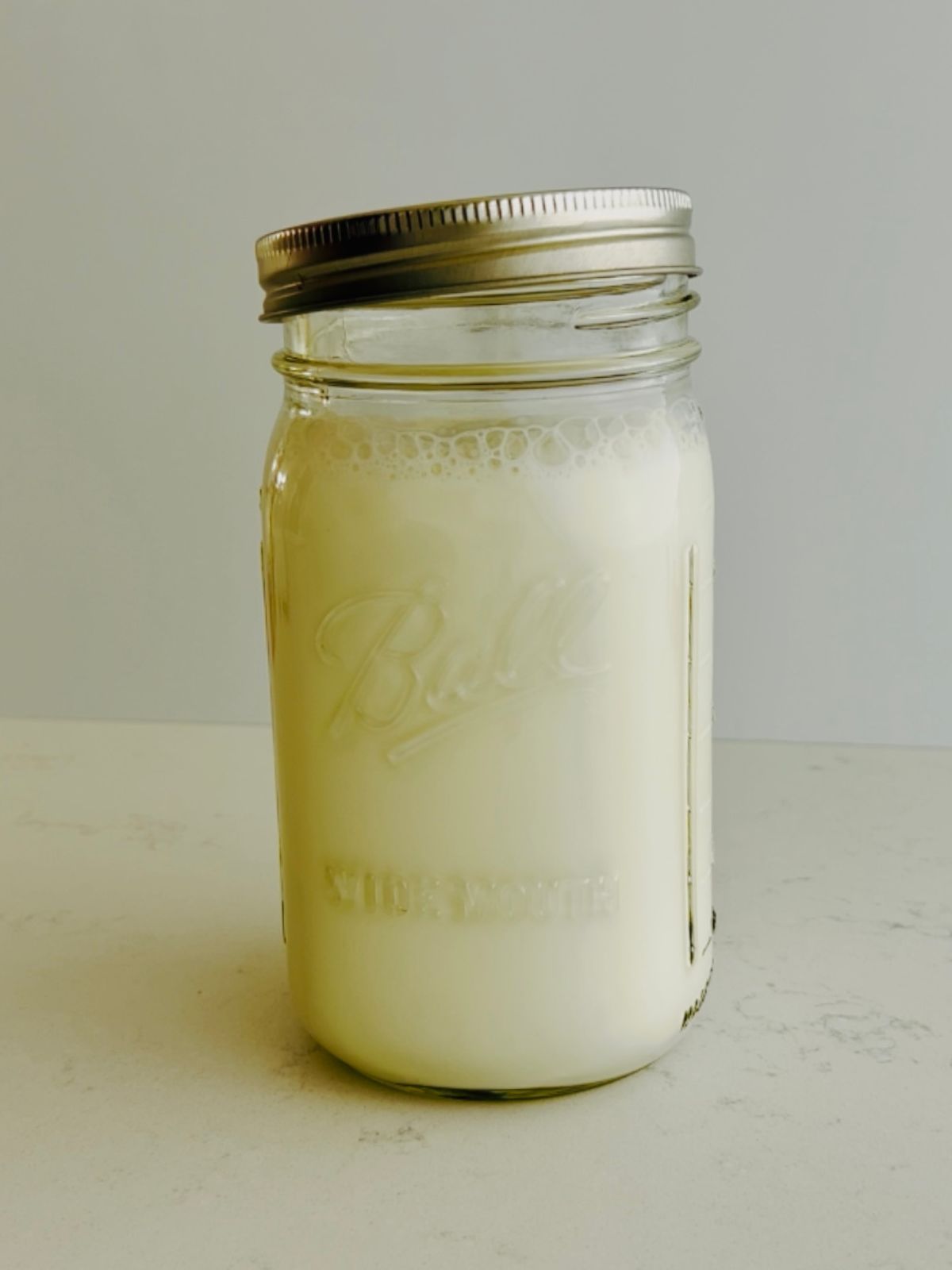 A mix of milk and buttermilk in a mason jar with the lid cracked open.
