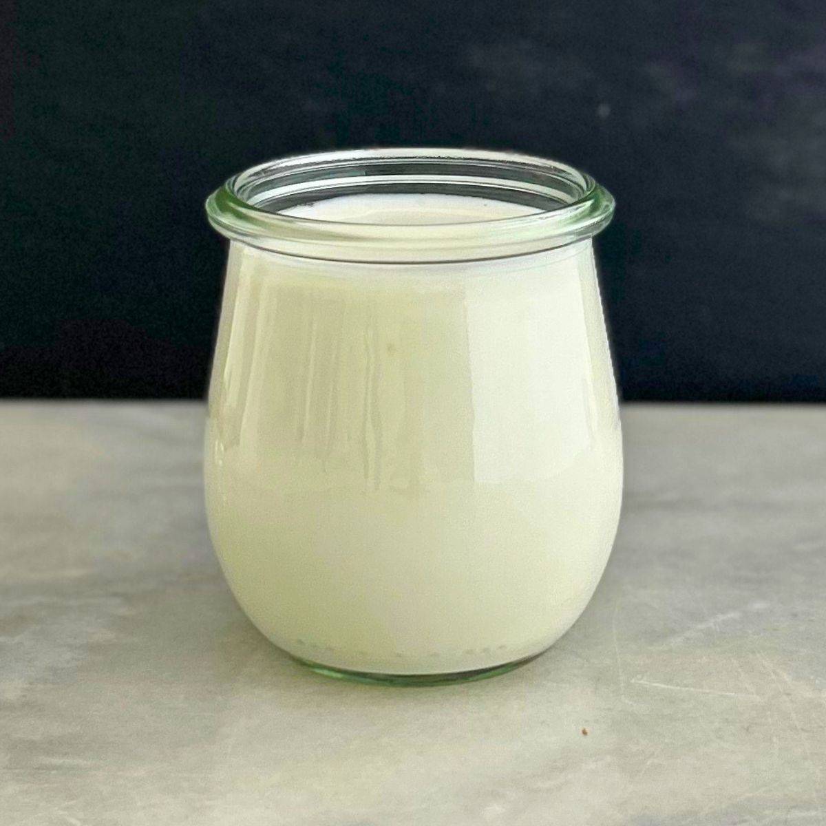 A recipe about how to make cultured buttermilk, with the finished buttermilk stored in a tulip-shaped glass jar.
