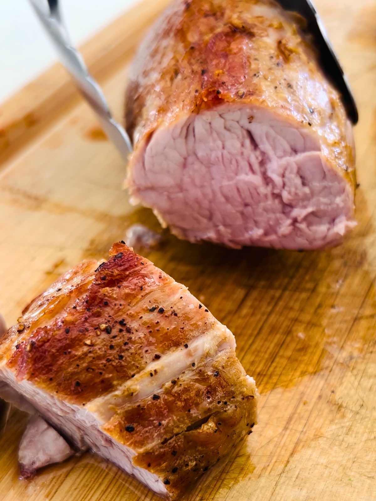 A cutting board with sliced roasted pork tenderloin.