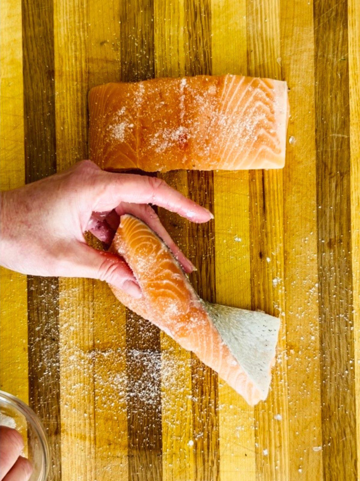 Salt and sugar are generously sprinkled over all sides of a salmon fillet to dry brine it.