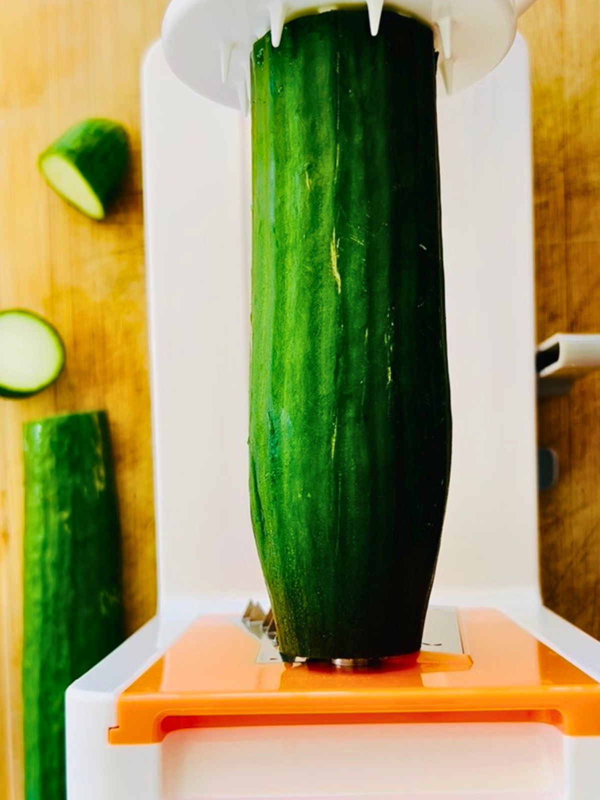 An English cucumber loaded into a countertop spiralizer, ready to be turned into fresh cucumber noodles.