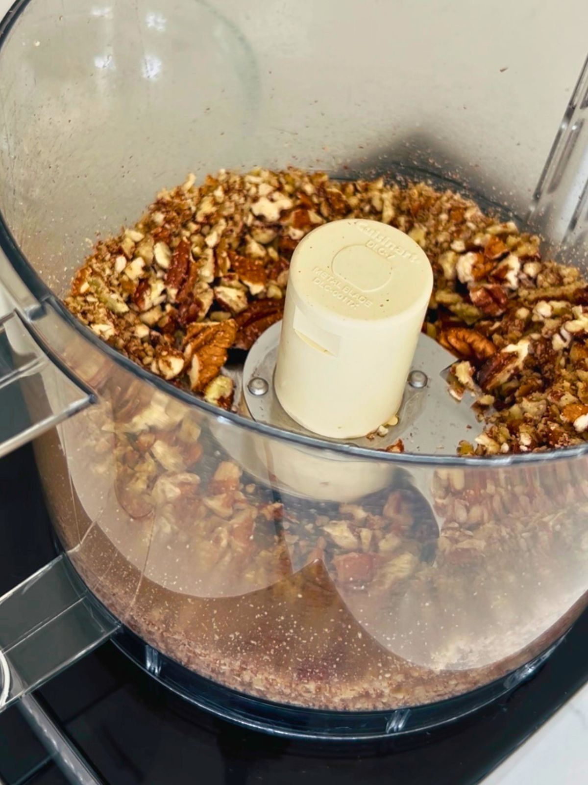 Roughly chopped pecans in a food processor bowl for the topping.