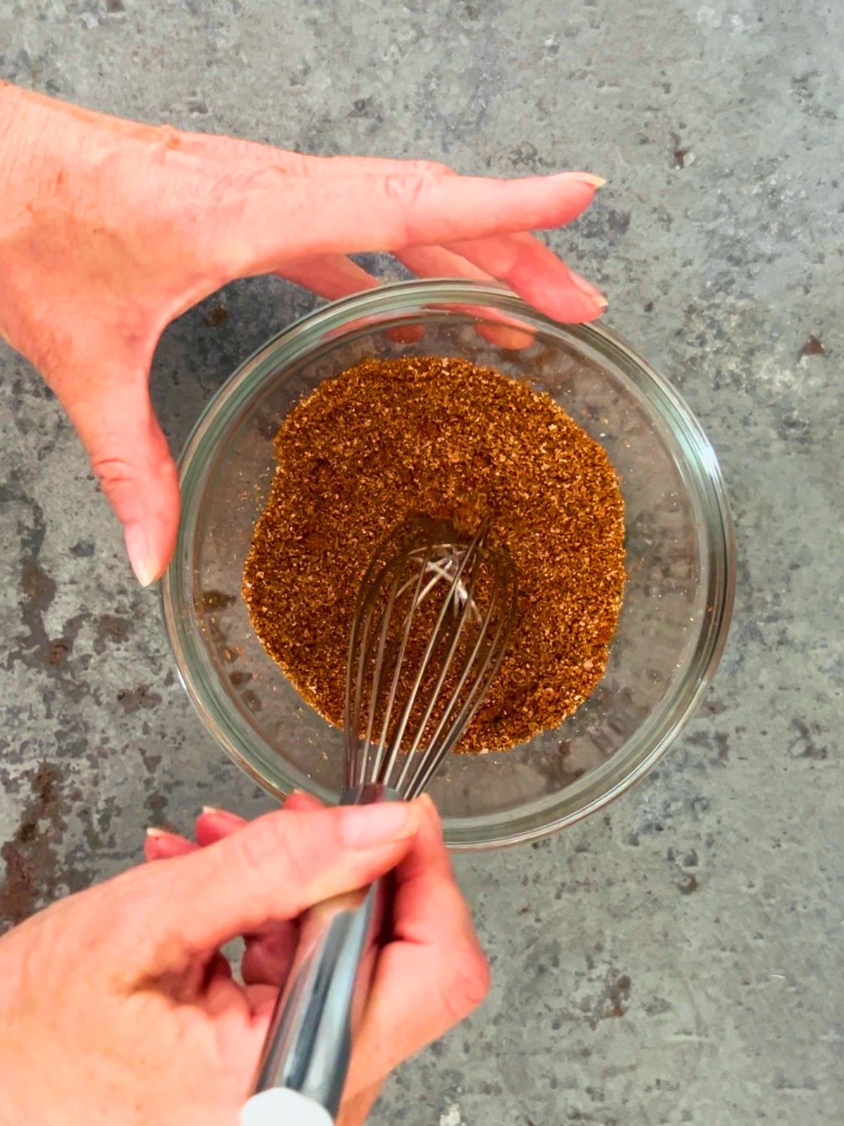 Whisking the spices in a glass bowl to make a small batch of taco seasoning with tomato powder.